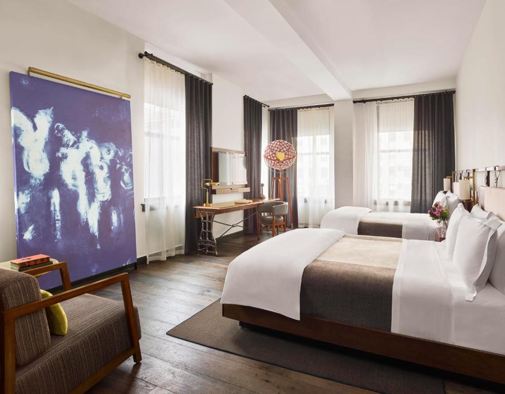 a hotel room with two beds and a couch at Refinery Hotel - New York in New York