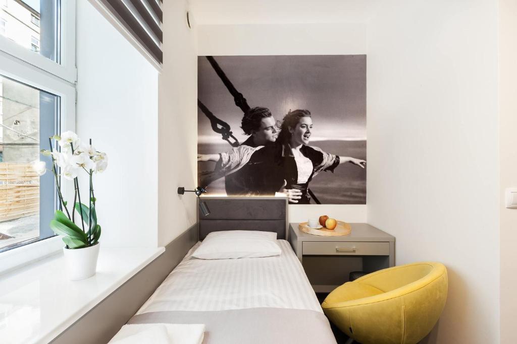 a bedroom with a bed and a poster of two women at Cinema Hostel in Poznań