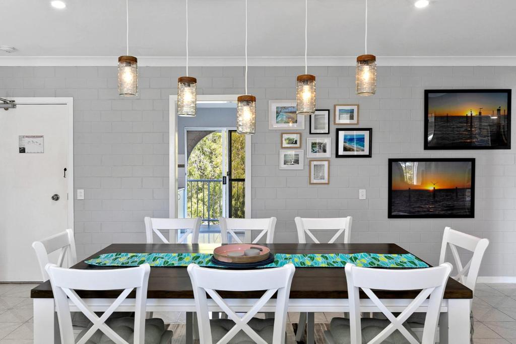 uma sala de jantar com uma mesa e cadeiras brancas em 21 The Islander Resort em Point Lookout