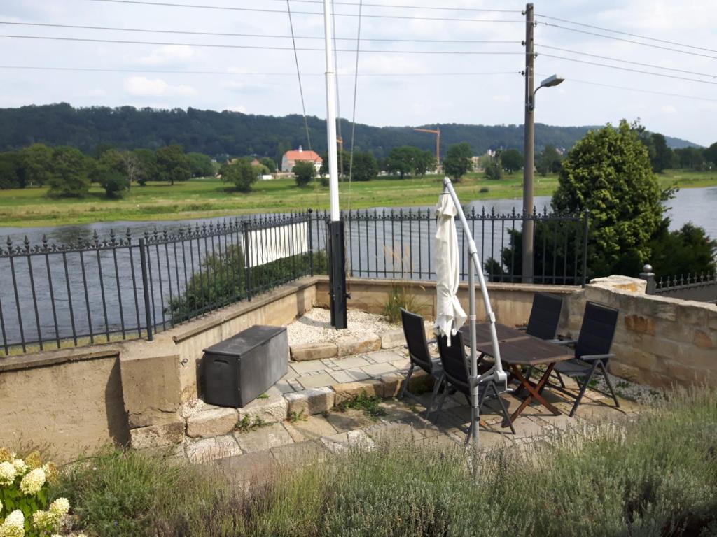 a table and chairs with an umbrella and a television at Ferienwohnung an der Elbe in Dresden
