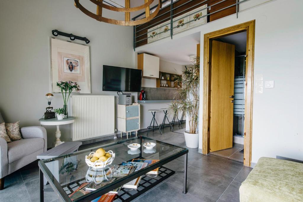 ein Wohnzimmer mit einem Glastisch und einem Sofa in der Unterkunft Loft Apartments in Komotiní