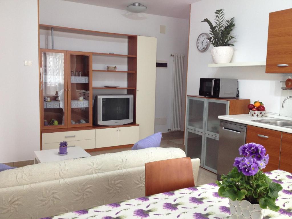 een woonkamer met een bank en een keuken bij LA CASA DELLE CONCHIGLIE ombrellone, parcheggio e uso di biciclette gratis in Rimini