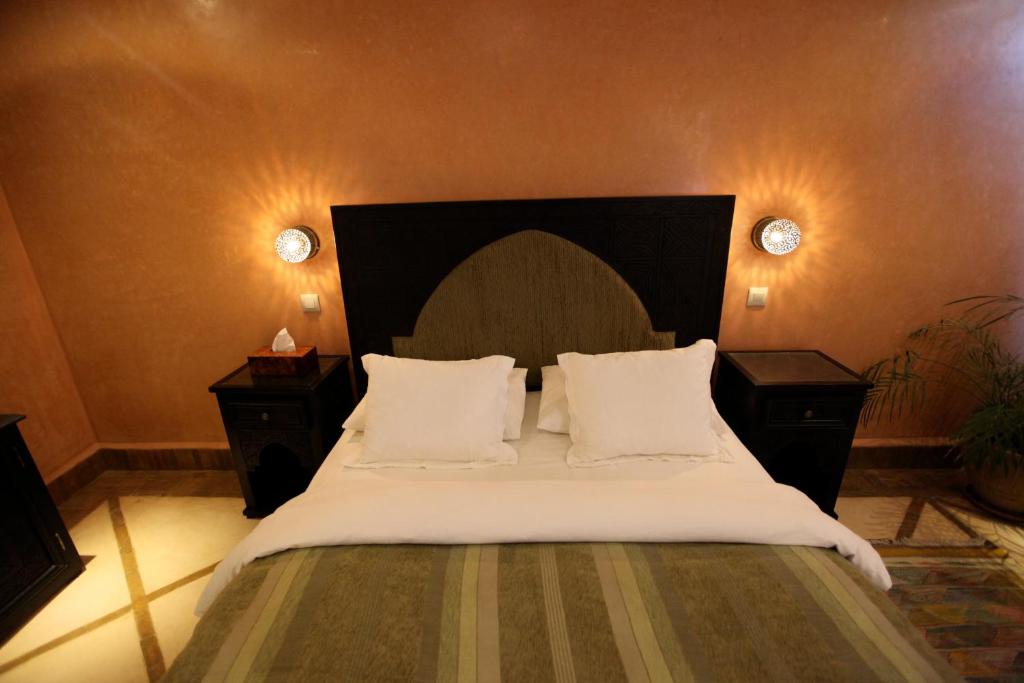 a bedroom with a large bed with white sheets and pillows at Riad Dar Haven in Tamraght Ou Fella