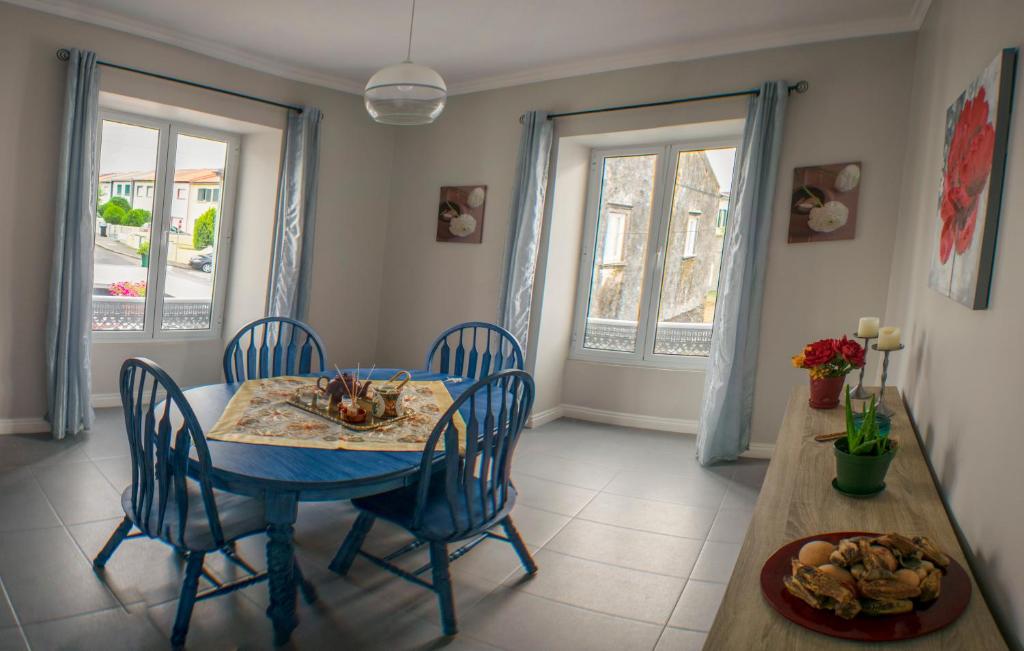 a dining room with a blue table and chairs at Maria's Haven in Santo António