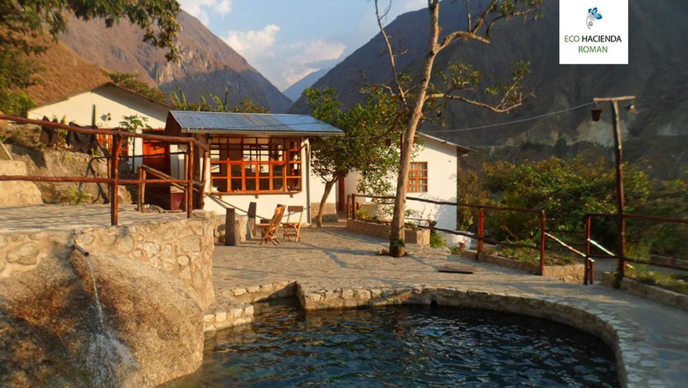 une petite piscine d'eau en face d'un bâtiment dans l'établissement Eco Hacienda Roman, à Machu Picchu