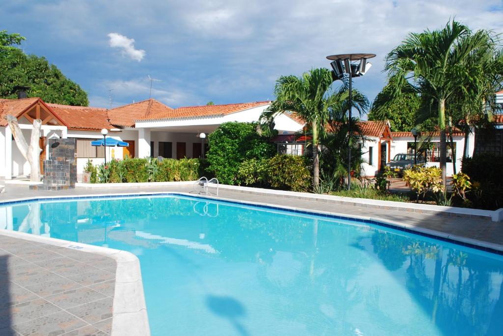 a large blue swimming pool in front of a house at Hotel Villa Ricaurte in Girardot