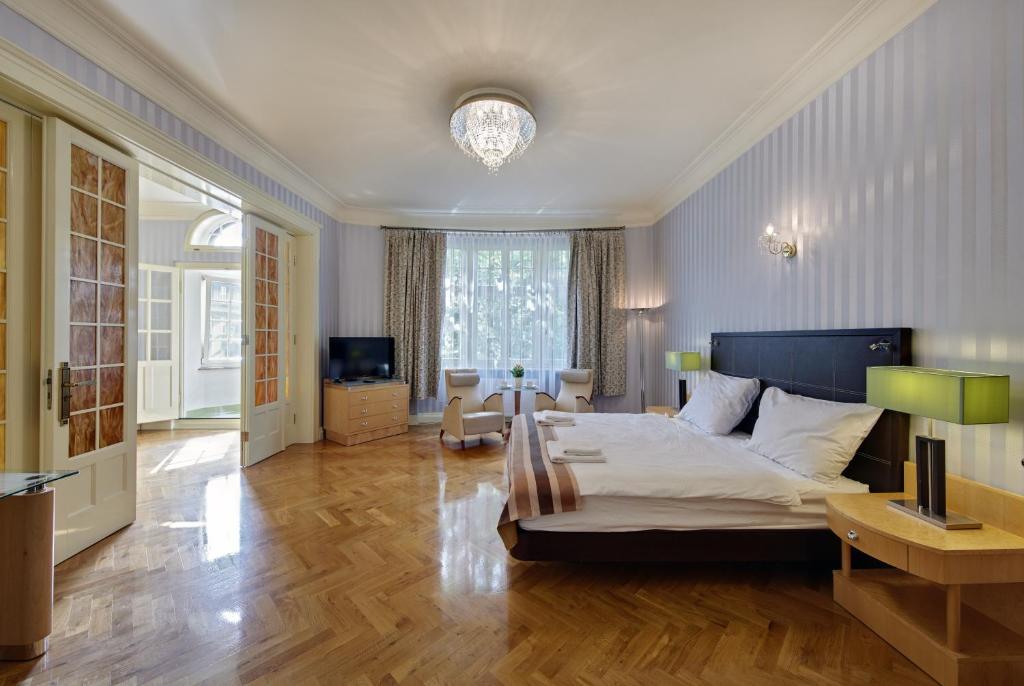カトヴィツェにあるApartament Kryształowyのベッドルーム(大型ベッド1台付)、リビングルームが備わります。