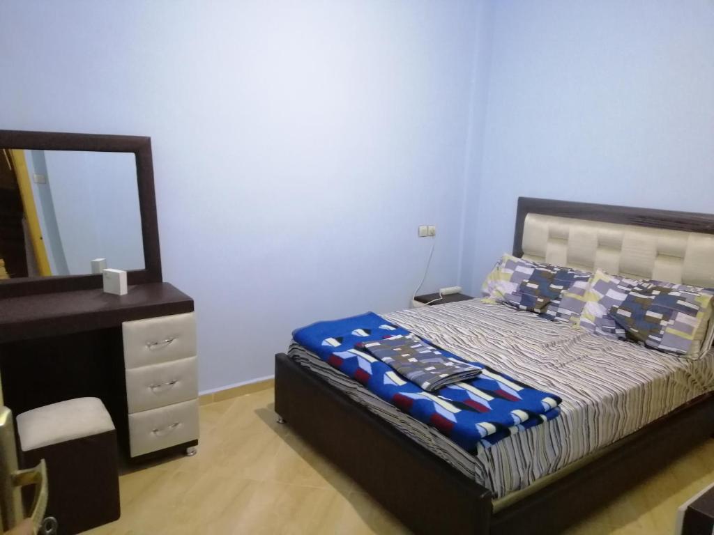 Schlafzimmer mit einem Bett, einer Kommode und einem Spiegel in der Unterkunft Best Room 2 in Fès