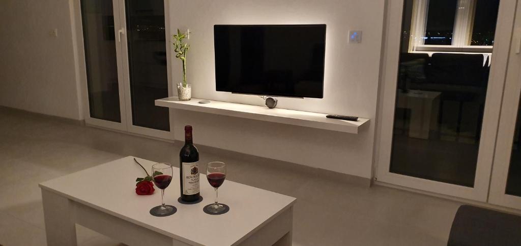 een woonkamer met een tafel met wijnglazen en een televisie bij ecoSmart Apartments Granada in Granada