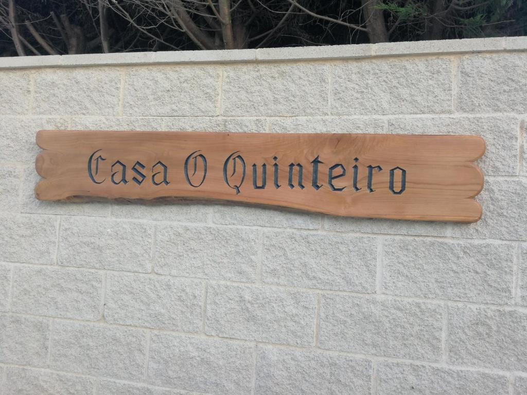 een bord dat zegt casa o quintero op een stenen muur bij CASA O QUINTEIRO in Vimianzo