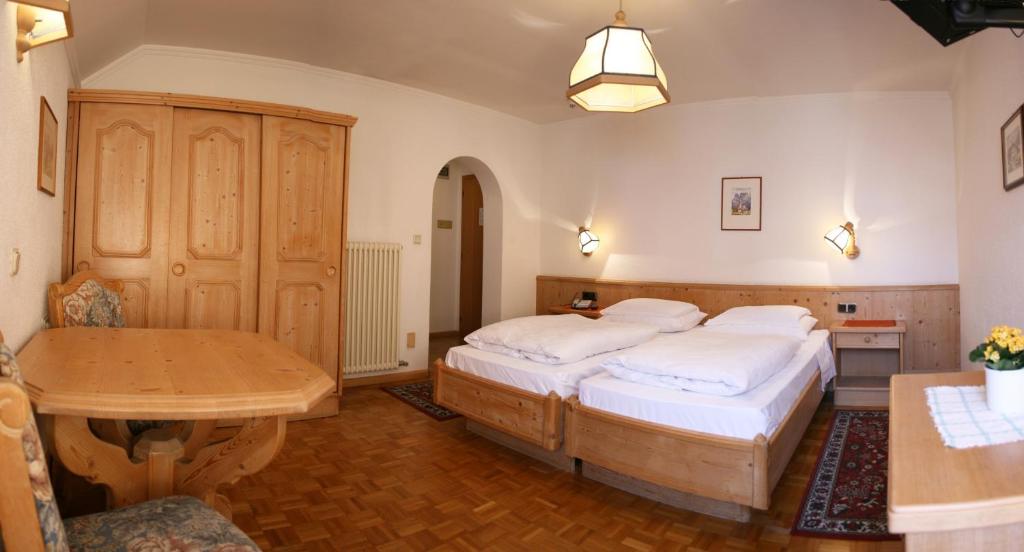 Łóżko lub łóżka w pokoju w obiekcie Hotel Dolomiti Madonna