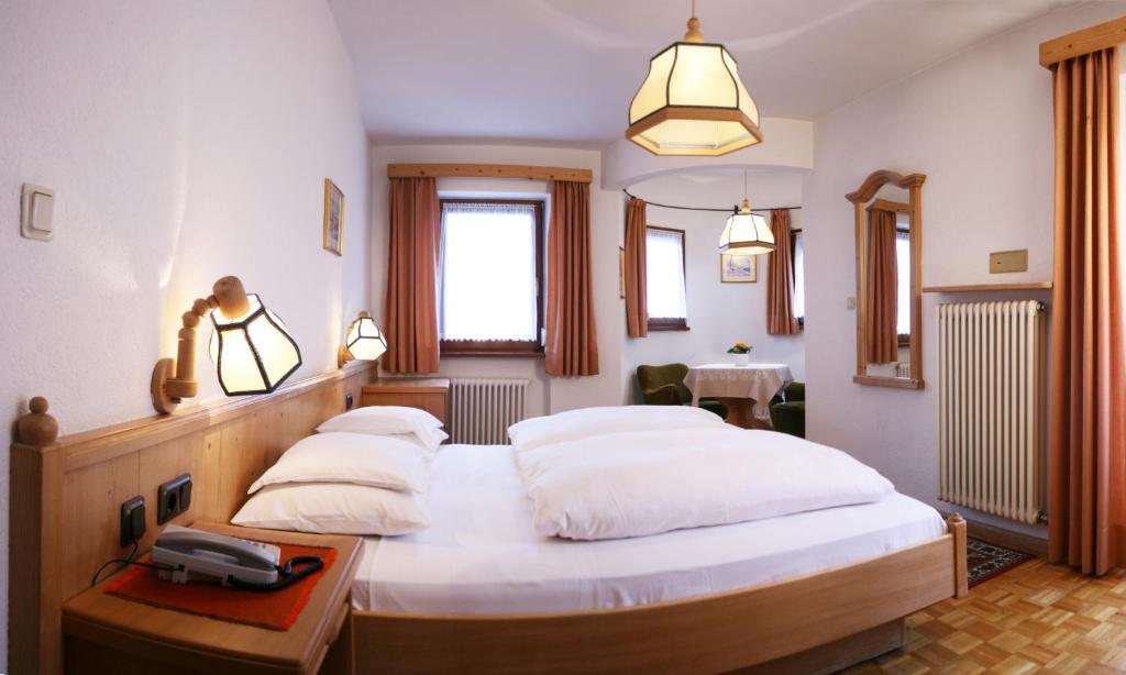 Łóżko lub łóżka w pokoju w obiekcie Hotel Dolomiti Madonna