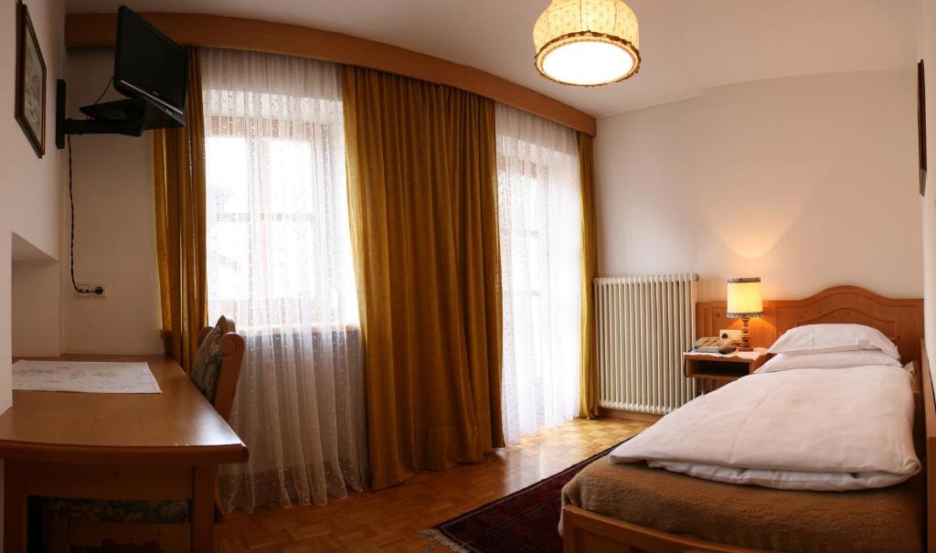 Łóżko lub łóżka w pokoju w obiekcie Hotel Dolomiti Madonna