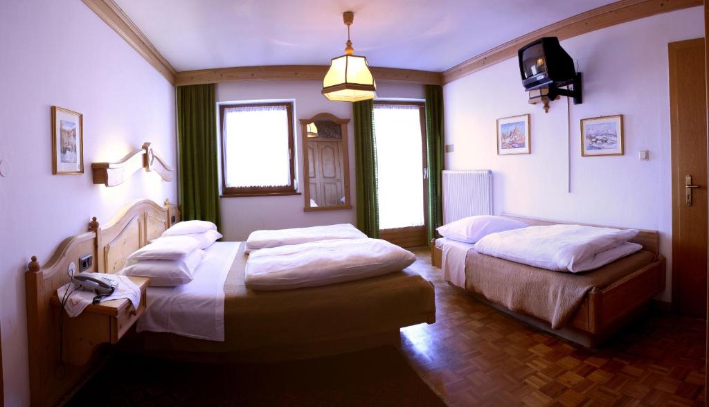 Łóżko lub łóżka w pokoju w obiekcie Hotel Dolomiti Madonna