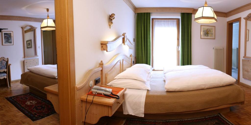 Łóżko lub łóżka w pokoju w obiekcie Hotel Dolomiti Madonna