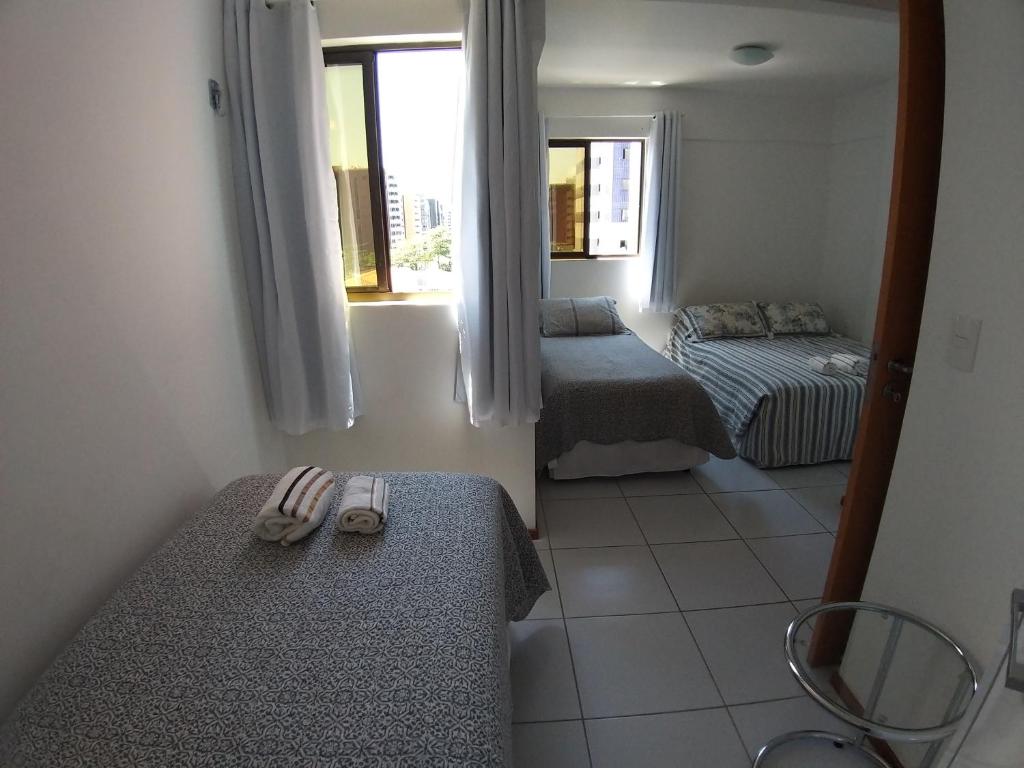 Cette petite chambre comprend 2 lits et une fenêtre. dans l'établissement Apartamento Edifício Edécio Lopes, à Maceió