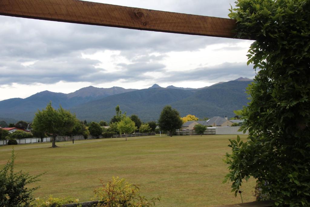 a view of a field with mountains in the background at Batch with a View in Te Anau