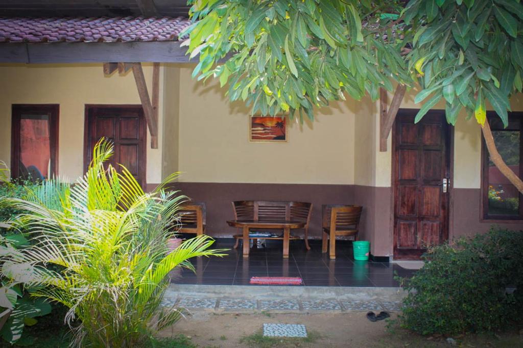 eine Veranda eines Hauses mit Stühlen und einem Tisch in der Unterkunft Harrys Oceanhouse 2 Pacitan in Pacitan