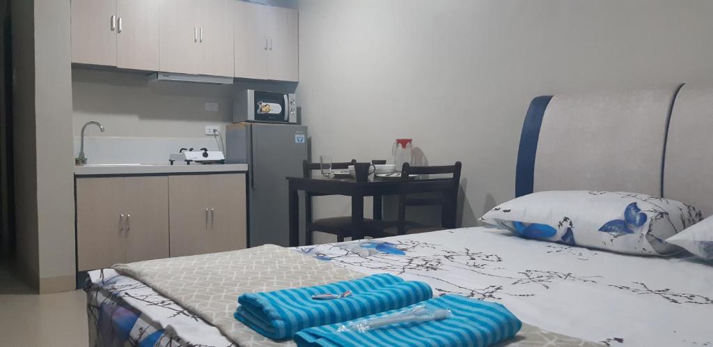 Una habitación con una cama con dos toallas azules. en Your Holiday Home( Studio, King Size Bed), en Mactan