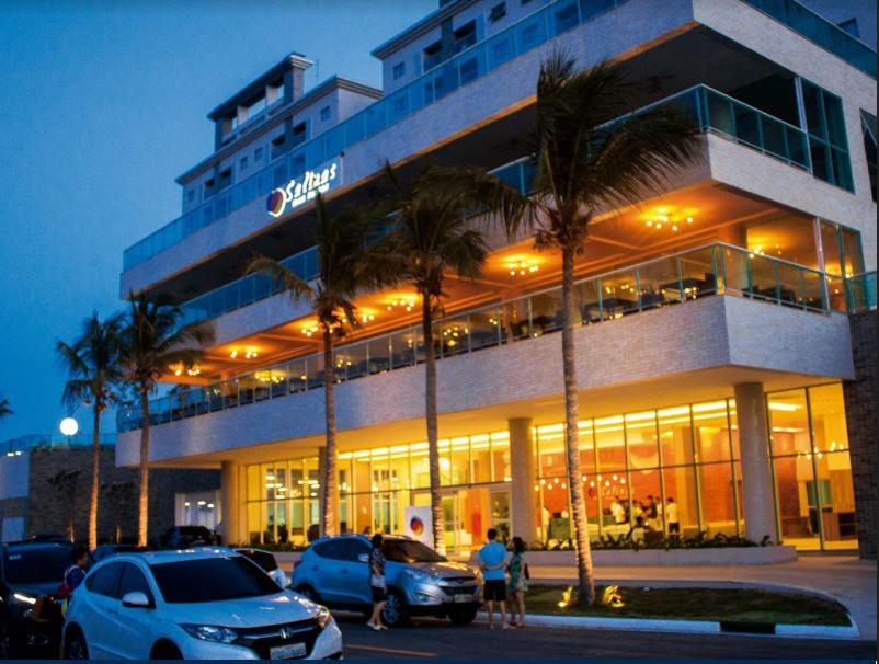 a building with cars parked in front of it at Salinas Park Resort in Salinópolis