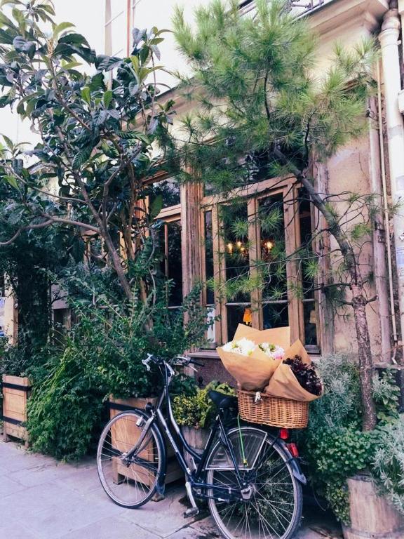 un vélo garé devant un bâtiment avec des paniers dans l'établissement Boutique Hotel de la Place des Vosges, à Paris