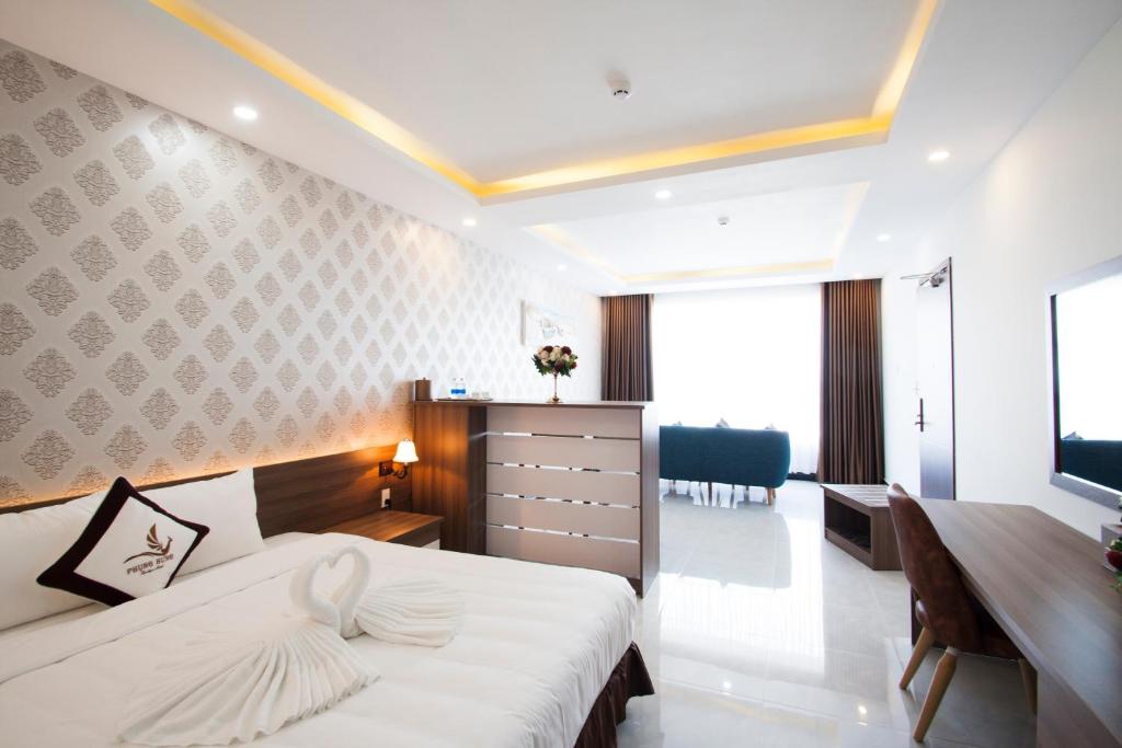 フーコックにあるPhung Hung Boutique Hotelのベッド、デスク、デスクが備わる客室です。