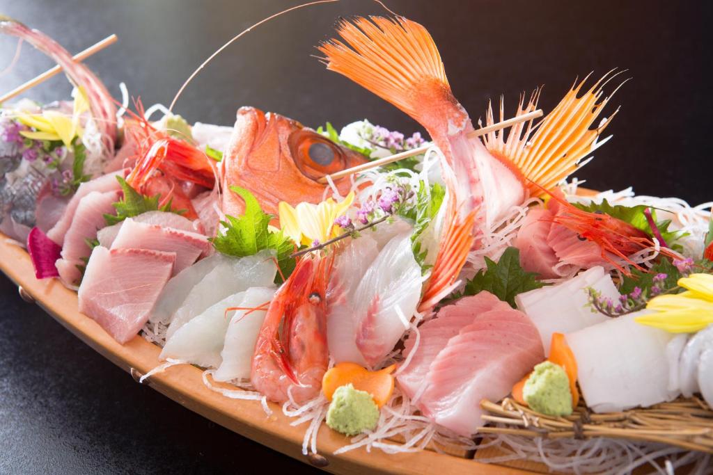 um prato de sushi com peixe e outros alimentos em Hamabe no Yado Asahiya em Himi
