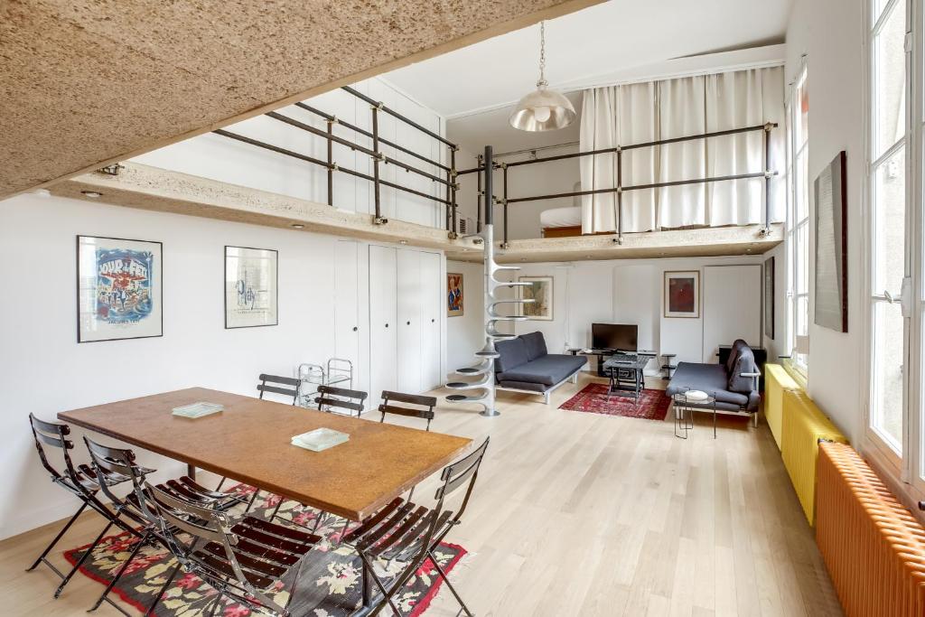 uma sala de jantar e sala de estar com mesa e cadeiras em Unit 010 Cherche Midi 19 em Paris