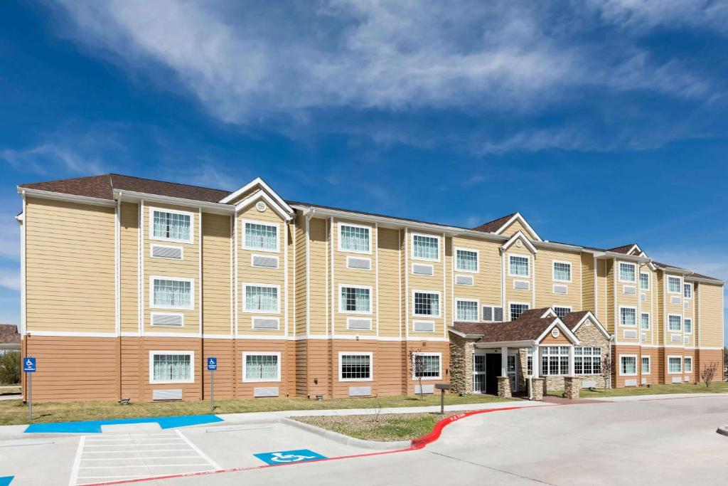 a large apartment building with a parking lot at Microtel Inn and Suites by Wyndham Monahans in Monahans