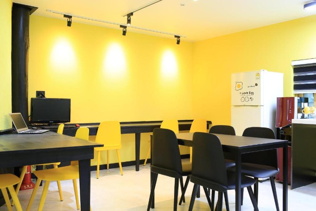 uma sala de jantar com cadeiras e mesas amarelas em Daegwanryeong Egg Guesthouse em Pyeongchang