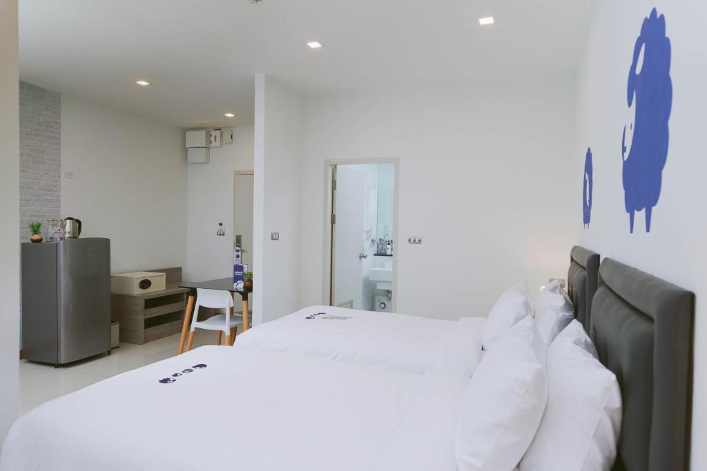 A twin room seen from the beds, with a refrigerator, tea station and compact dining desk.