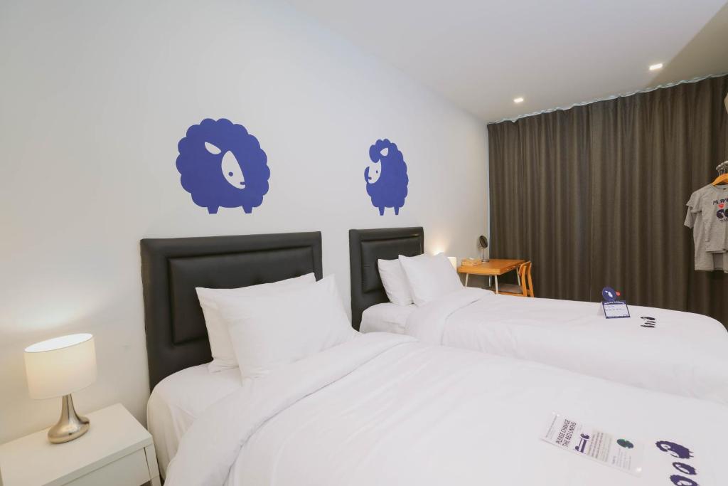 A twin room with two separate beds, a small desk and full-width curtains.