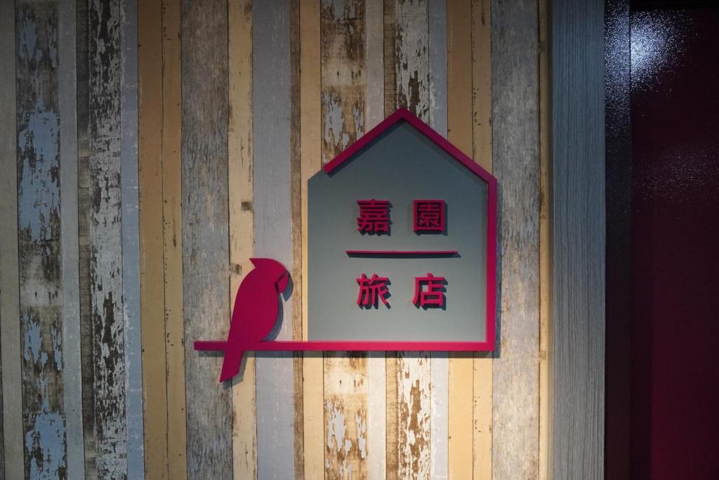 ein Schild an der Wand mit einem roten Vogel drauf. in der Unterkunft Jia Inn in Tainan