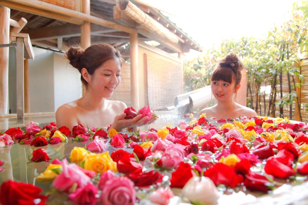 Duas mulheres estão numa mesa de flores. em Kotohira Grand Hotel Sakuranosho em Kotohira