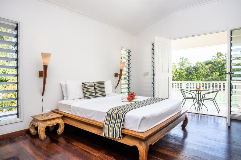 a bedroom with a large bed in a room with a balcony at Tropicana Lagoon Apartments in Port Vila