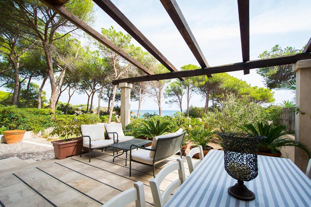 een patio met een tafel en stoelen en de oceaan bij Casa Vacanze Rosa Maria in Orosei