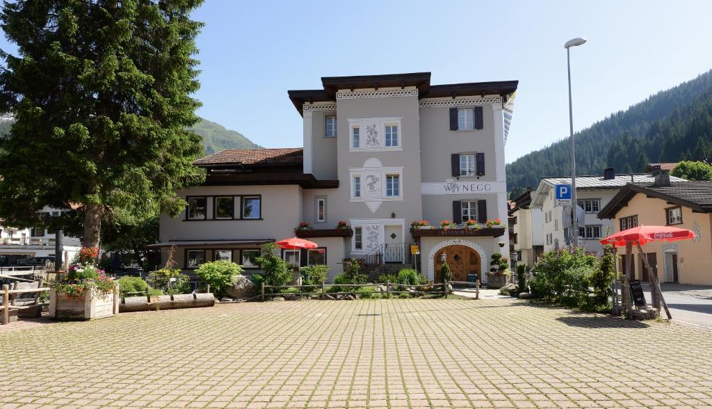 a large building with a courtyard in front of it at Hotel Wynegg in Klosters