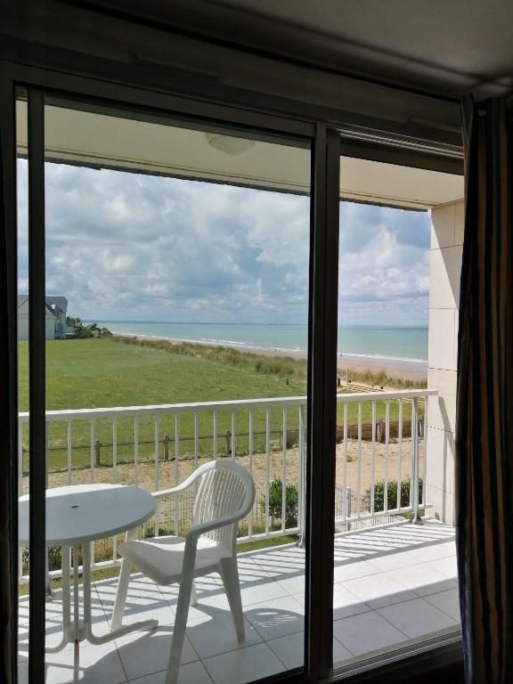 un balcon avec une table et une vue sur l'océan dans l'établissement résidence de la plage, à Jullouville