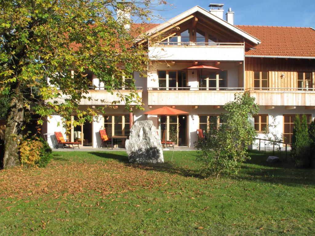 une grande maison avec un grand rocher dans la cour dans l'établissement Ferienlandhaus Alpinum, à Lenggries