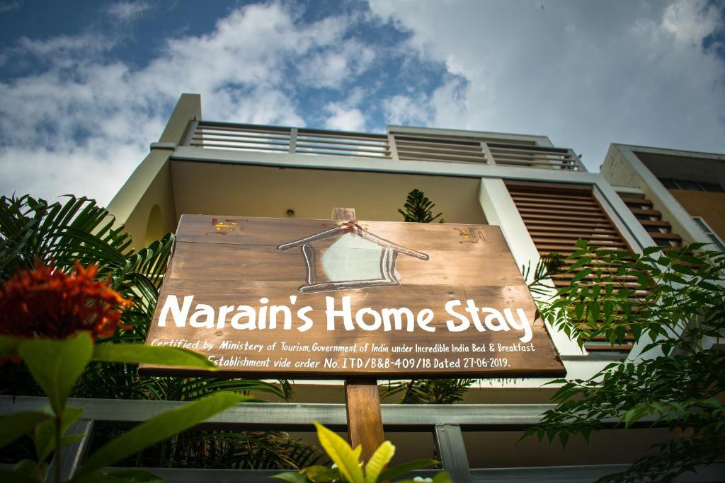 a sign in front of a building with a home stay sign at Narain's Homestay in Kāshīpur