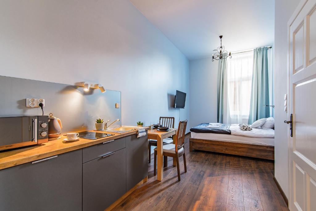 Pokój z kuchnią i sypialnią z łóżkiem w obiekcie Oak Tree Old Town Apartments w Krakowie