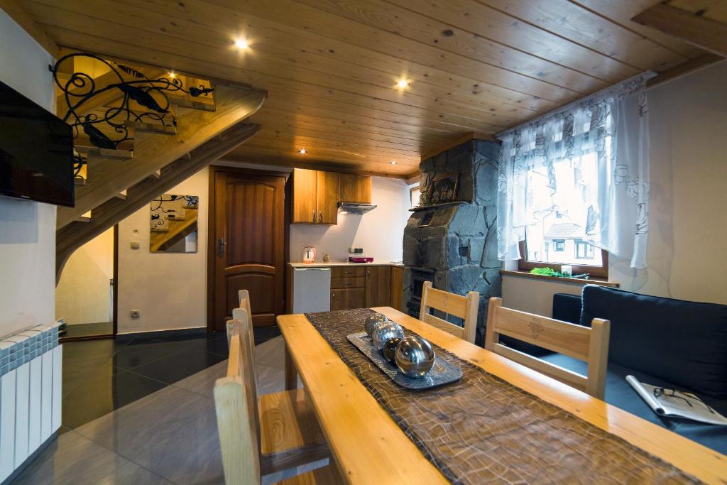 a dining room with a wooden table and a kitchen at Apartament An-Mi in Zakopane