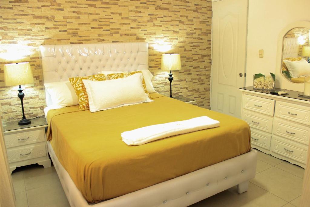 1 dormitorio con 1 cama grande con sábanas y almohadas amarillas en Fully Equipped New 3br Apt–dt–2mins To The Beach, en Sosúa