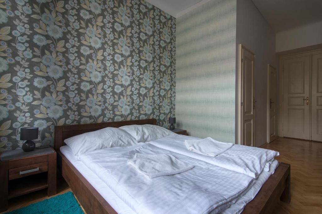 - une chambre dotée d'un lit avec des draps blancs et un papier peint floral dans l'établissement Great place near city centre, à Prague