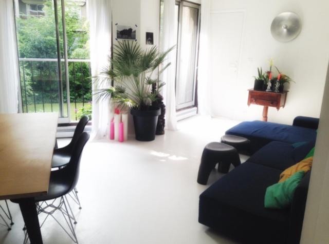 un salon avec un canapé bleu et une table dans l'établissement Havre de paix en plein Paris, à Paris