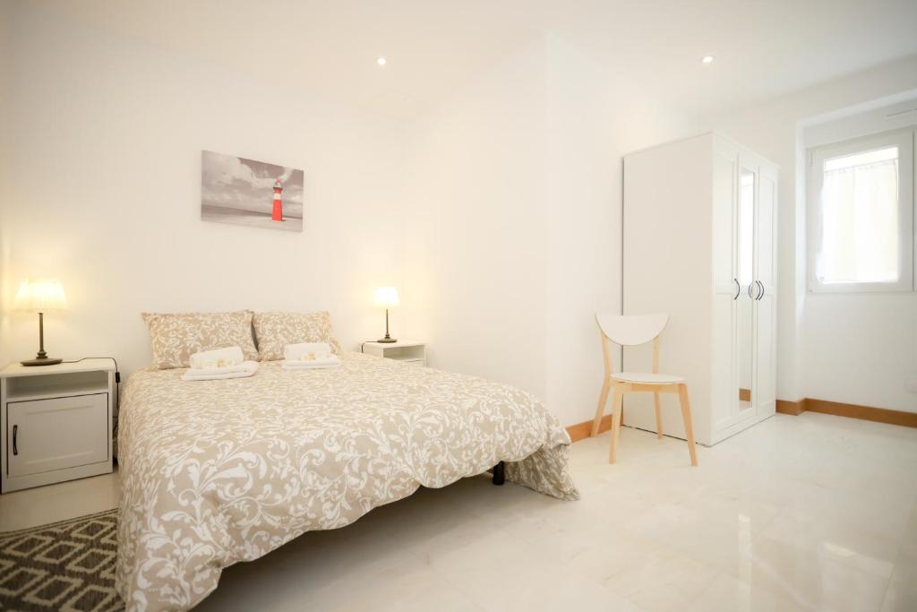 - une chambre blanche avec un lit et deux lampes dans l'établissement Apartamento Casino Praia III, à Figueira da Foz