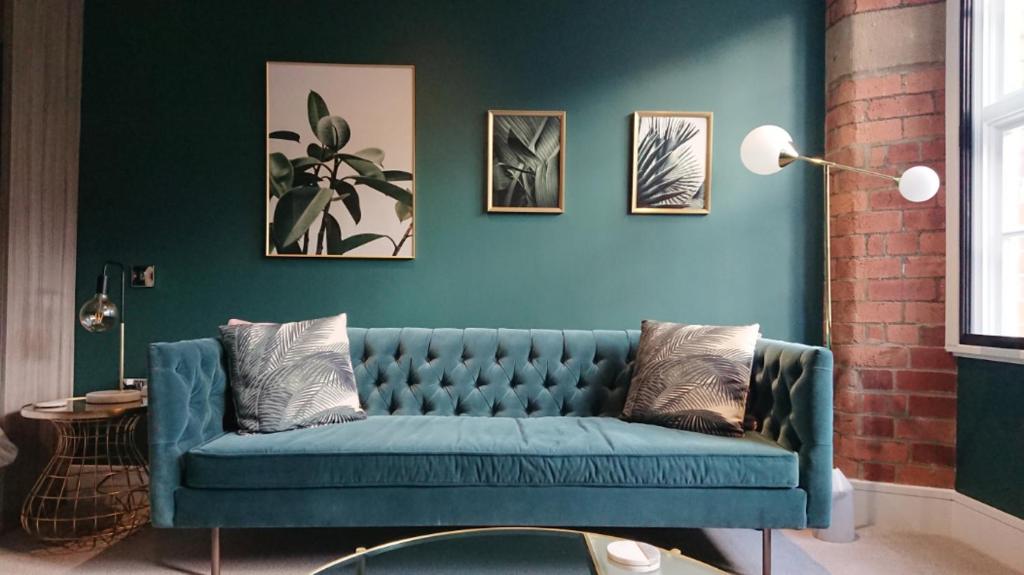 a blue couch in a living room with a wall at I Should Cocoa (York) - Joseph in York