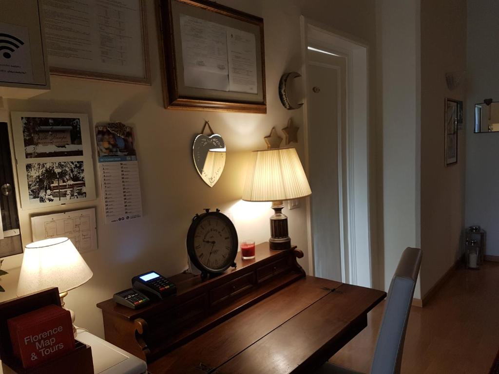 una habitación con una mesa con reloj y una lámpara en Villa Alle Rampe, en Florencia