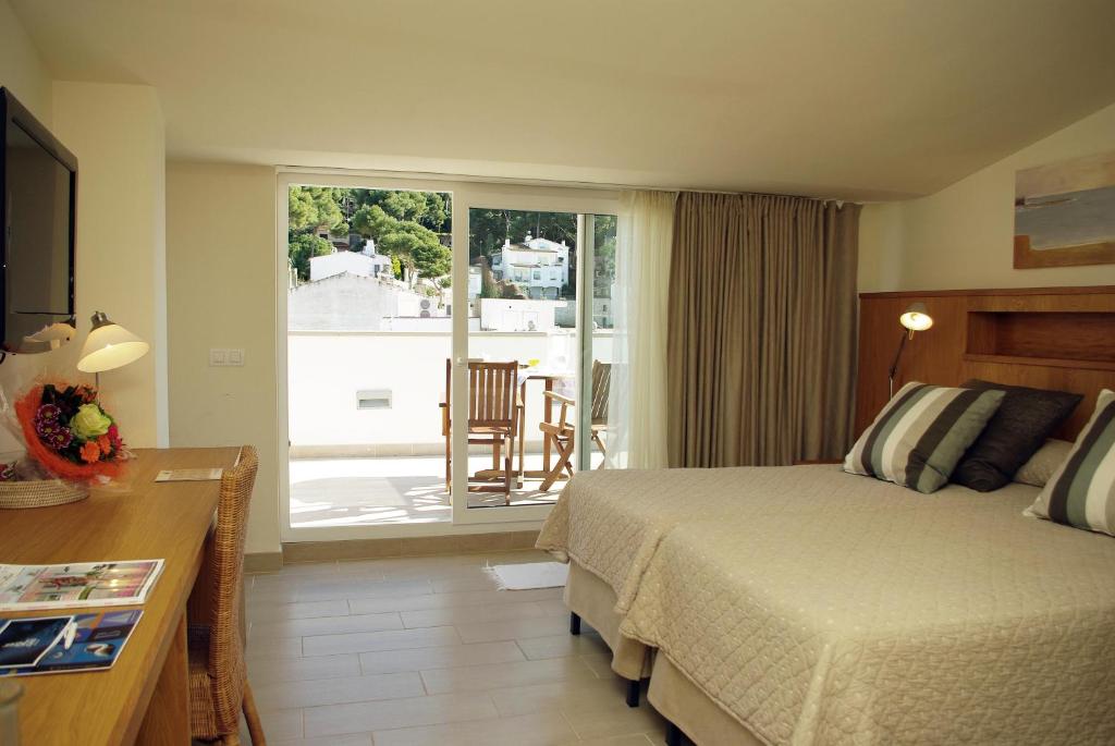 a hotel room with a bed and a balcony at Hotel Llafranch in Llafranc