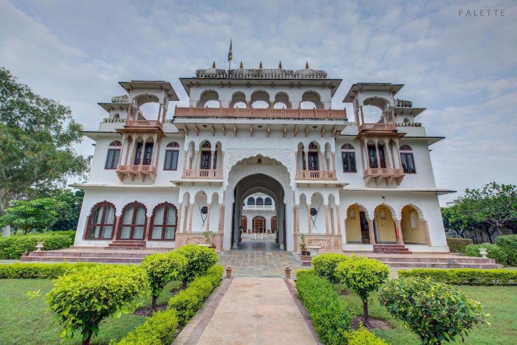 a large white house with a pathway leading to it at Talabgaon Castle Heritage Resort in Sarīma